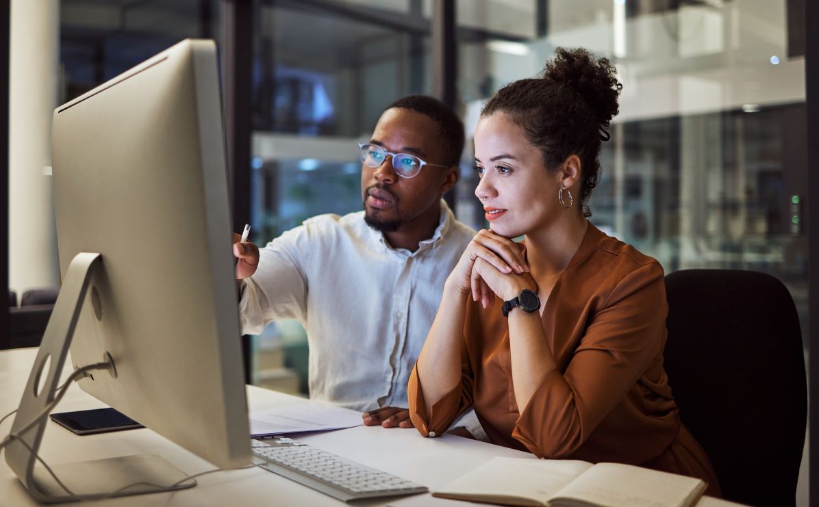 man and woman viewing computer screen